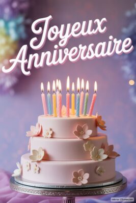 Gâteau d'anniversaire à trois étages rose pâle, décoré de fleurs pastel et de bougies allumées multicolores, sur fond flou violet.