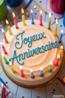 Gâteau d'anniversaire blanc avec bougies multicolores allumées, écrit «Joyeux Anniversaire» en bleu.
