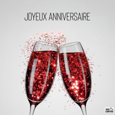 Illustration d'anniversaire avec deux flûtes de champagne rouge pétillant qui s'entrechoquent sur fond blanc, texte Joyeux Anniversaire