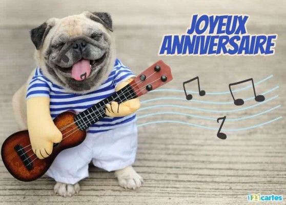 Carlin souriant tenant une guitare avec des notes musicales, portant un t-shirt rayé. Texte : Joyeux Anniversaire.