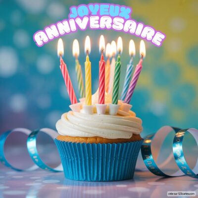 Cupcake festif avec crème, décoré de bougies colorées allumées, entouré de serpentin. Message Joyeux Anniversaire.