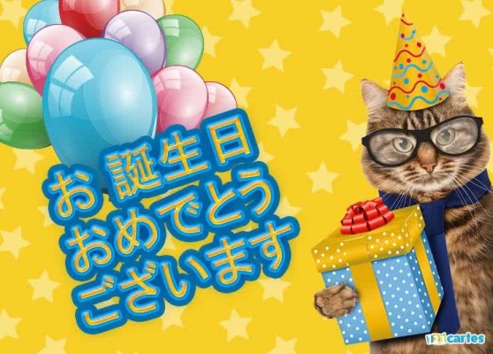 Chat portant un chapeau de fête et lunettes, tenant un cadeau, entouré de ballons colorés avec texte japonais sur fond jaune étoilé.