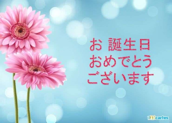 Fleurs roses sur fond bleu avec texte d'anniversaire en japonais. Atmosphère festive et lumineuse pour carte de vœux gratuite.